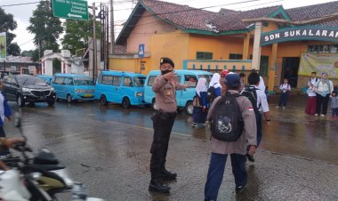 Aksi Humanis Anggota Polsek Sukalarang Bantu Menyeberangkan Anak Sekolah