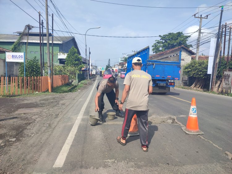 Aksi Polisi Dari Polsek Sukaraja  Perbaiki Jalan Berlubang