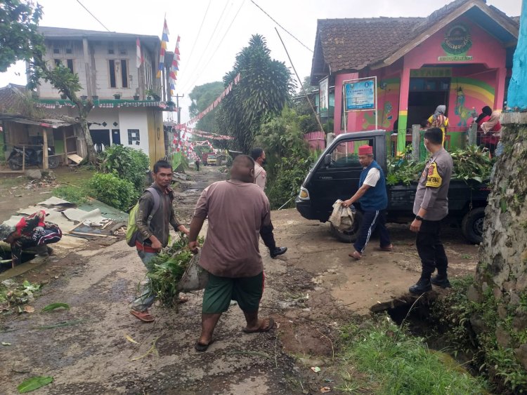 Bhabinkamtibmas Desa Titisan Bantu Warga Yang Sedang Laksanakan Kerja Bakti