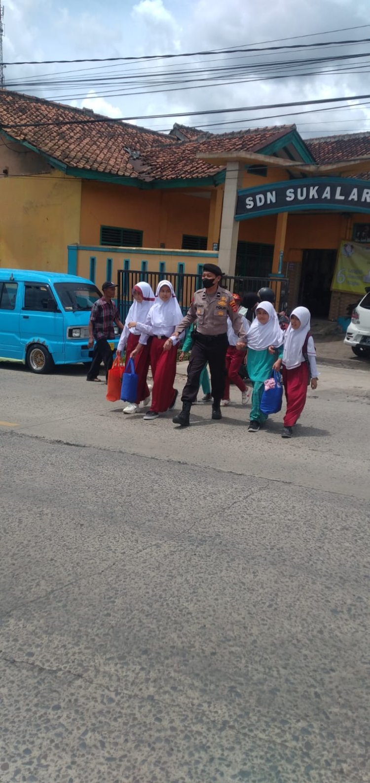 Aksi Humanis Anggota Polsek Sukalarang Bantu Siswa Sekolah Menyebrang Usai Pulang Sekolah