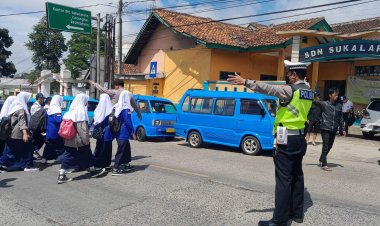 Personel Polsek Sukalarang Gatur Lalin, Bantu Anak Sekolah Menyeberang