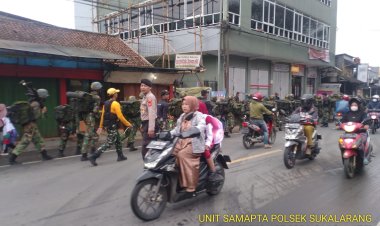 Personel Polsek Sukalarang Laksanaka Gatur Lalin Saat Kegiatan Longmarch TNI