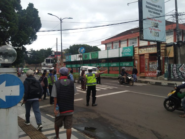 Lantas Polsek Cikole Bantu Sebrangkan Anak Sekolah