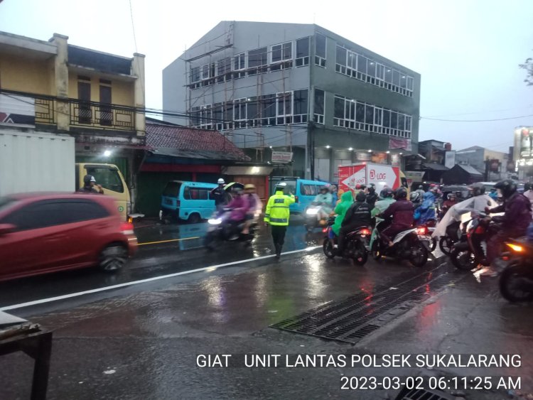 Diguyur Hujan, Polisi Polsek Sukalarang Tetap Laksanakan Gatur Lalin