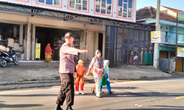 Anggota Unit Samapta Polsek Sukalarang Bantu Pelajar Menyeberang Jalan