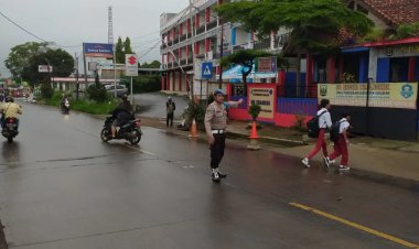 Polisi Bantu Siswa Sekolah Menyeberang Saat Gatur Lalin Pagi