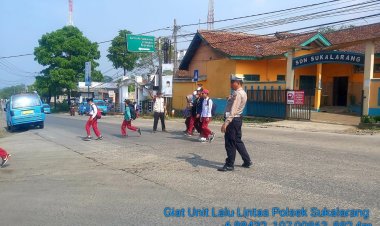 Polisi Bantu Siswa Sekolah Menyeberang Saat Gatur Lalin Pagi