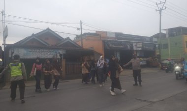 Sambil Gatur Lalin Pagi, Polisi Bantu Siswa Sekolah Menyeberang Saat Gatur Lalin