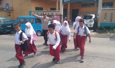 Peduli Keselamatan, Polisi Bantu Siswa Sekolah Menyeberang Saat Gatur Lalin
