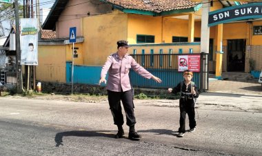 Polisi Bantu Siswa Sekolah Dasar Menyeberang Saat Gatur Lalin Pagi