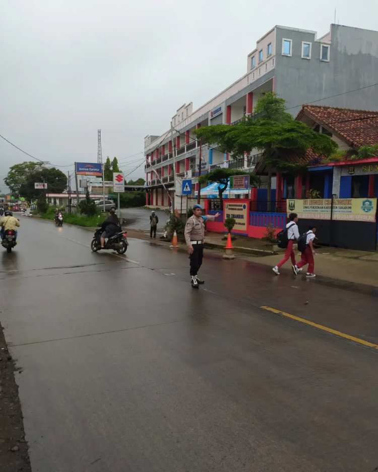 Polisi Bantu Siswa Sekolah Menyeberang Saat Gatur Lalin Pagi