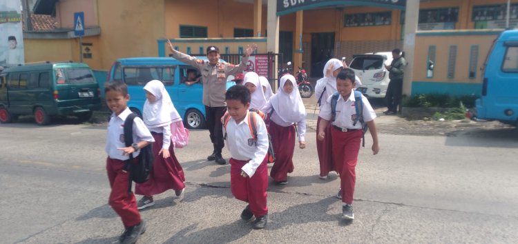 Peduli Keselamatan, Polisi Bantu Siswa Sekolah Menyeberang Saat Gatur Lalin