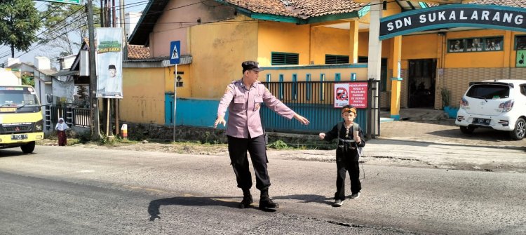 Polisi Bantu Siswa Sekolah Dasar Menyeberang Saat Gatur Lalin Pagi