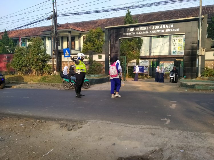 Setiap Pagi, Polisi  Membantu Anak Sekolah SMPN 1 Sukaraja menyebrang jalan